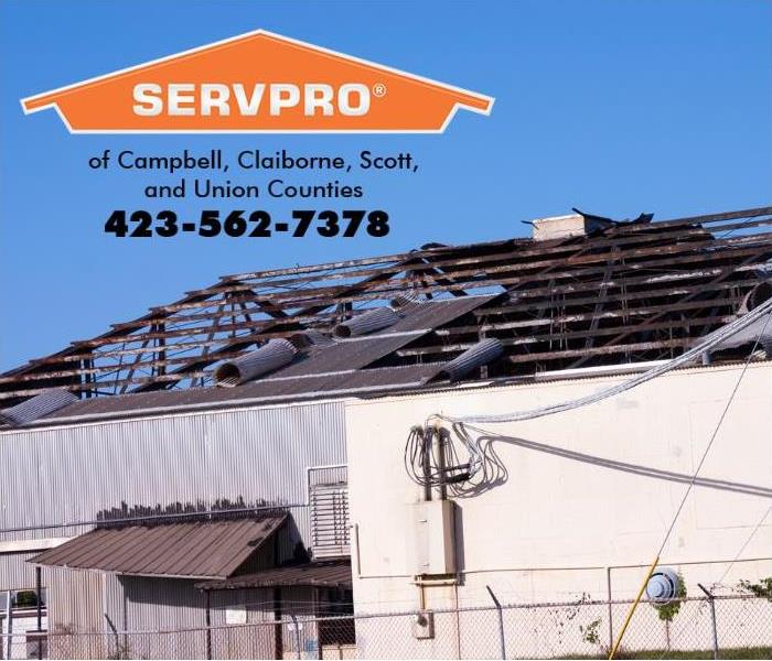 The roof of a commercial business is shown with wind damage. 
